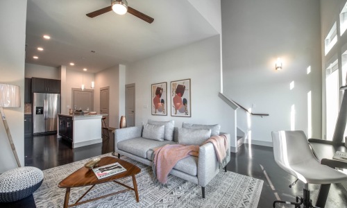 Model living room at our luxury apartments in Flower Mound, featuring couches and a view of the kitchen.