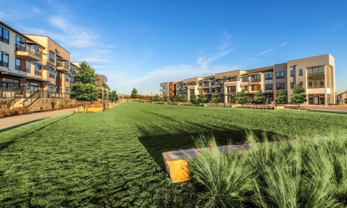 The grounds at our apartments in Flower Mound, TX, featuring a large grassy field and a view of the apartment complex.